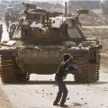 Un palestinien face à un char Israélien
